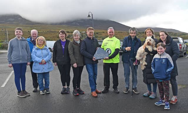 Frank McCarrick, Chairman of Murrisk Development Association and Fr John Kenny, pictured with a commemorative stone donated by Charlie Bird (right) (Pic: Conor McKeown)