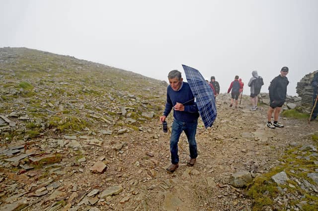 A pilgrim bearing an umbrella reaches the summit of Croagh Patrick (Pic: Conor McKeown)