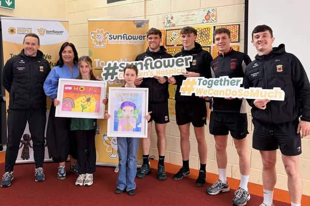 Mayo GAA senior team manager Andy Moran and players Jack Coyne, Jordan Flynn, Cian McHale and Kobe McDonald pictured with St. Aidan's N.S pupils Emilia Lee Farrell and Charlotte Rose Corless, who finished first and second respectively in Category 2 of Pamex Ltd's Linking Little Lives colouring competition in aid of Sunflower Children's Hospice. Also in the photo is Martina Jennings, CEO of Mayo Roscommon Hospice Foundation