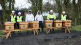 Astatine team members and beekeeping support pictured behind 6 beehives set up at the Ballina astatine site.