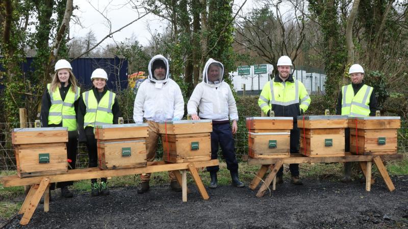 Astatine team members and beekeeping support pictured behind 6 beehives set up at the Ballina astatine site.